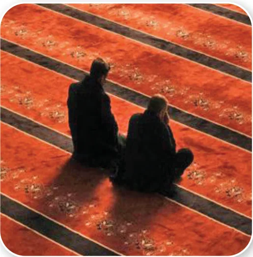 صورة لشخصين يجلسان جنبًا إلى جنب في مسجد
